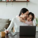 cute little ethnic girl embracing working mother